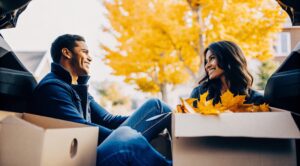 Μετακόμιση το φθινόπωρο με τη Prime: Νεαρό ζευγάρι πακετάρει κούτες με συμβουλές μετακόμισης στην αυλή.