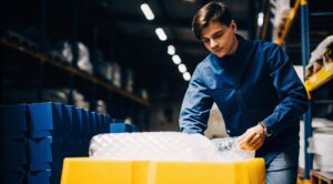 A Prime businessman wraps glasses with bubble wrap, showing the proper protection of fragile products in transit