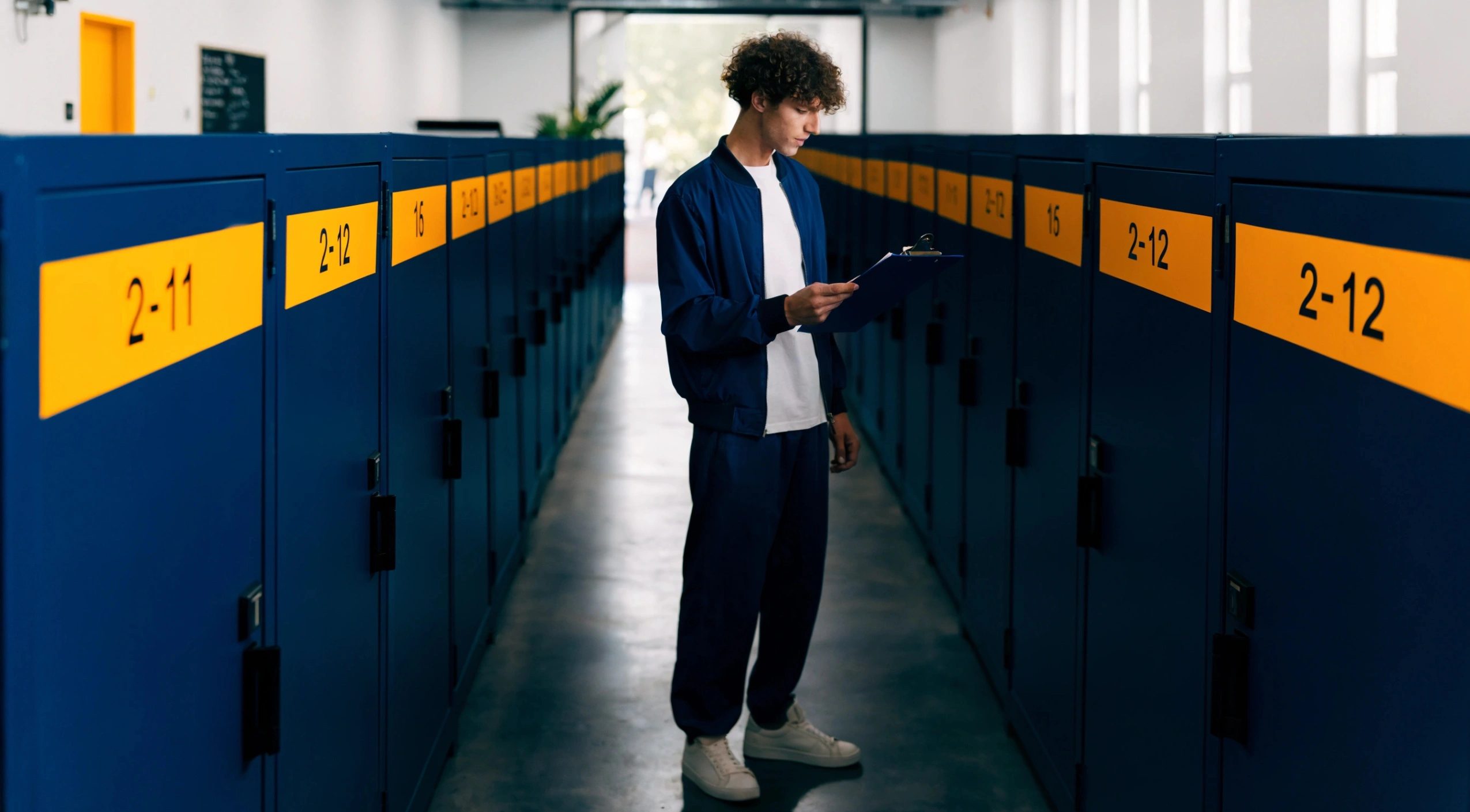 Επιχειρηματίας σε αποθηκευτικό χώρο Prime με αποθηκευτικούς χώρους, οργανωμένους και ασφαλείς, ελέγχει τις σύγχρονες λύσεις αποθήκευσης για την επιχείρησή του