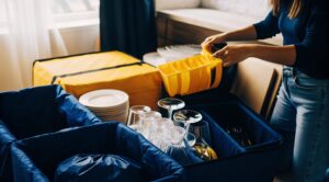 Γυναίκα συσκευάζει κουζίνα με προϊόντα Prime, εφαρμόζοντας σωστή συσκευασία κουζίνας για ασφαλή μετακόμιση