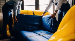 Επαγγελματίες της Prime δείχνουν τον σωστό τρόπο για μετακόμιση επίπλων, τυλίγοντας προσεκτικά έναν καναπέ πριν τη μεταφορά