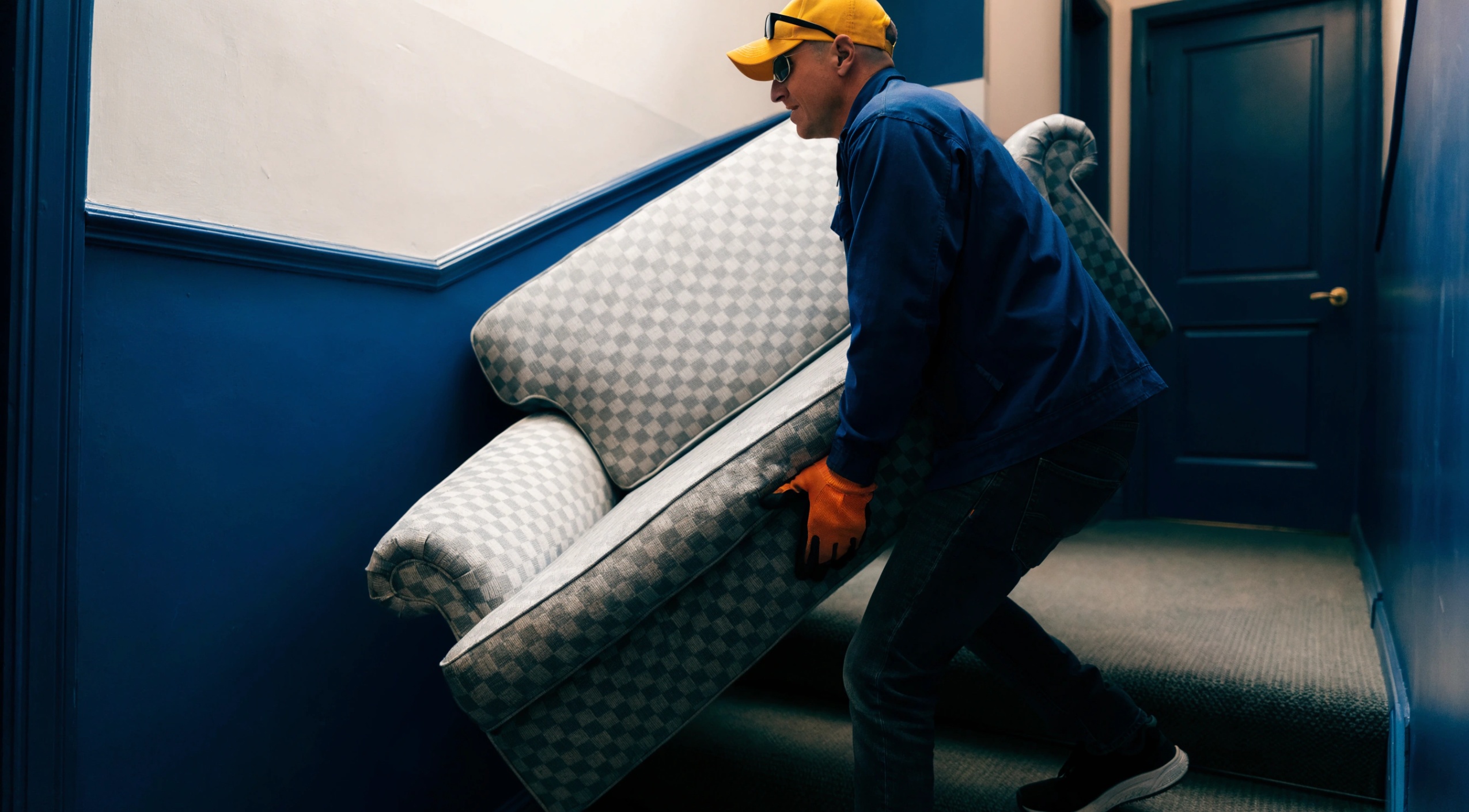 Μετακομιστής της Prime ανεβάζει καναπέ στις σκάλες, δείχνοντας τις επιπλέον χρεώσεις μετακόμισης λόγω σκάλας